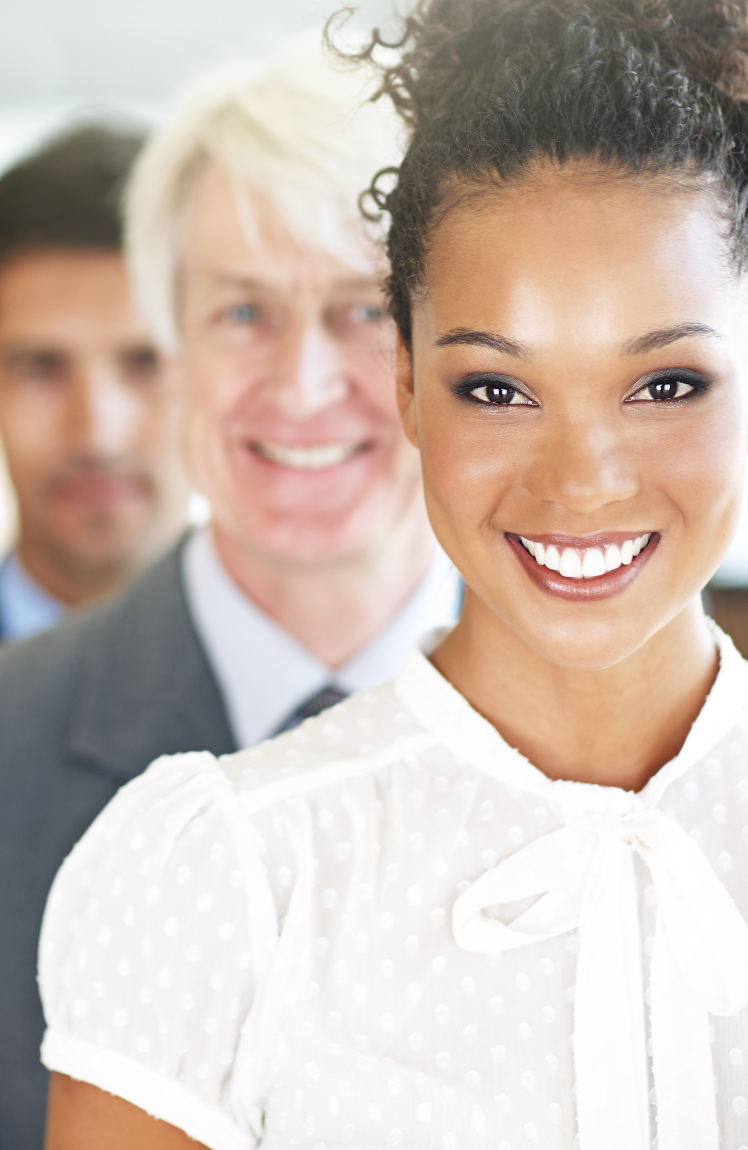 Three business leaders standing in line, smiling — the case for leadership development