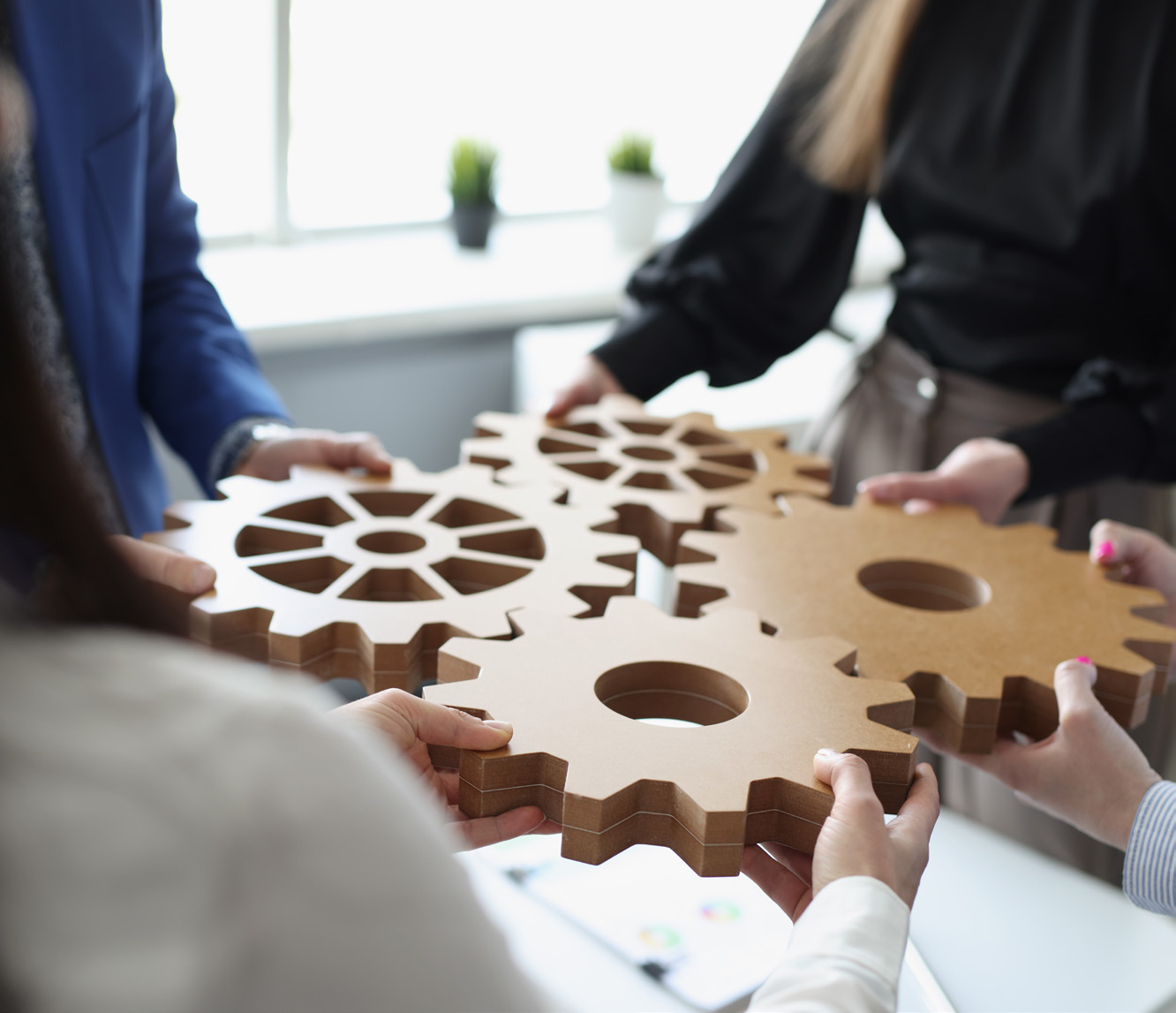 Hands assembling interlocking wooden gears