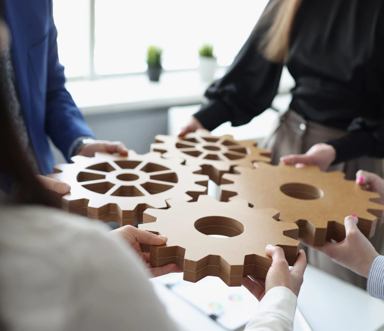 Hands assembling interlocking wooden gears